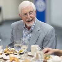 Gentleman smiling while looking over chatting with Emily Spranger